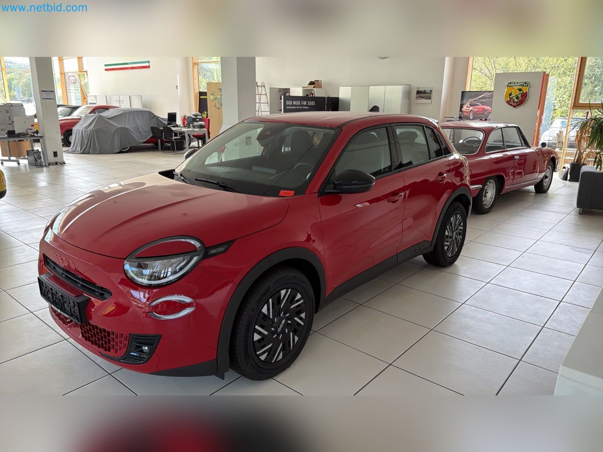 Passenger cars, electric cars, and automotive repair shop equipment at a Fiat dealership-1